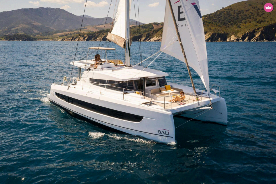 Catamaran à voile avec cabines naviguant devant la Costa Blanca