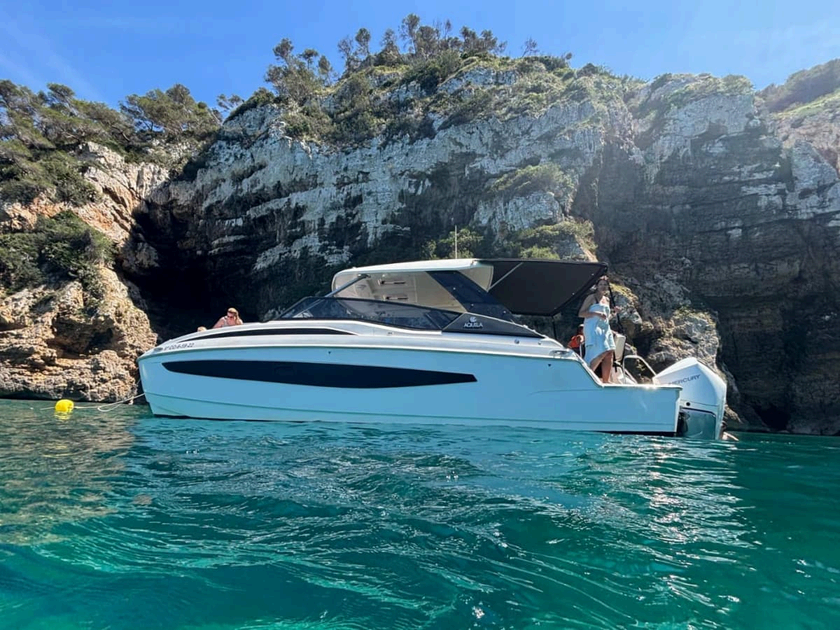 Catamaran à moteur mouillé au pied des falaises de la Costa Blanca au coucher du soleil