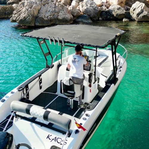 Bateau à moteur Kaos d'Infinaissance amarré dans une crique aux eaux turquoise près de Dénia